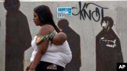 People walk along a downtown street in Johannesburg, South Africa, Monday, March 16, 2020. Millions of women and girls globally have lost access to contraceptives, abortion services and related care because of the coronavirus pandemic. (AP Photo/Themba Hadebe)