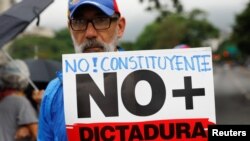 Un partidario de la oposición tiene un cartel que dice "No a la asamblea constituyente. No más dictadura". Maduro renuncia "durante una protesta contra el presidente de Venezuela, Nicolás Maduro, en Caracas, Venezuela el 2 de mayo de 2017.