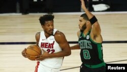 Sep 15, 2020; Lake Buena Vista, Florida, USA; Miami Heat forward Jimmy Butler (22) drives to the basket while Boston Celtics forward Jayson Tatum (0) defends during the first half in game one of the Eastern Conference Finals of the 2020 NBA Playoffs at ES