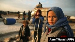 Syrian children prepare to flee with their families a camp for the displaced east of Sarmada town in northwestern Idlib province amid an ongoing pro-regime offensive, February 16, 2020. (Aaref Watad/AFP) 