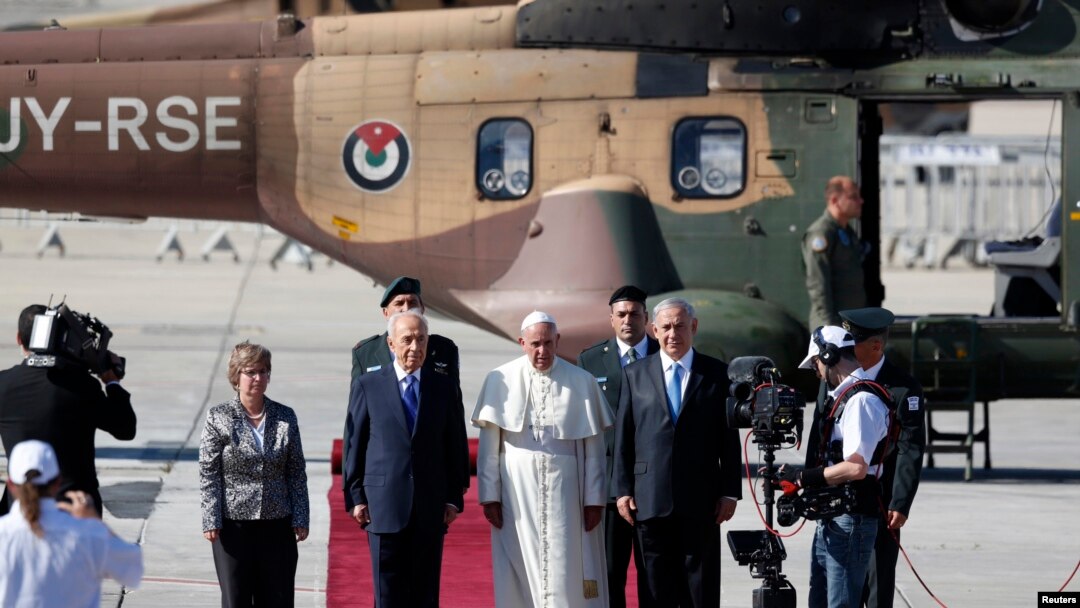 Presiden Israel Shimon Peres (tengah kiri) dan Perdana Menteri Benjamin Netanyahu (tengah kanan) berdiri dengan Paus Fransiskus (tengah) di karpet merah setelah Paus mendarat di bandara internasional Ben Gurion dekat Tel Aviv, 25 Mei 2014. 