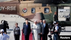 Presiden Israel Shimon Peres (tengah kiri) dan Perdana Menteri Benjamin Netanyahu (tengah kanan) berdiri dengan Paus Fransiskus (tengah) di karpet merah setelah Paus mendarat di bandara internasional Ben Gurion dekat Tel Aviv, 25 Mei 2014. 