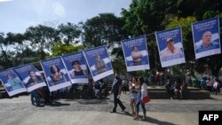 Sejumlah foto dari tahanan politik yang ditahan oleh pemerintah Nikaragua terpampang dalam sebuah protes yang dilakukan oleh para eksil Nikaragua di Guatemala pada 7 November 2021. Mereka memprotes pemilu yang dimenangkan kembali oleh Daniel Ortega. (Foto: AFP)