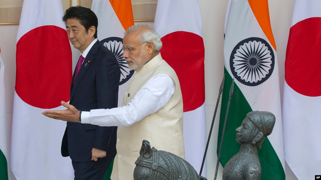 Indian Prime Minister Narendra Modi, right, shows the way to his Japanese counterpart Shinzo Abe as they arrive for their meeting, in New Delhi, India, Dec. 12, 2015. 