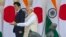 Indian Prime Minister Narendra Modi, right, shows the way to his Japanese counterpart Shinzo Abe as they arrive for their meeting, in New Delhi, India, Dec. 12, 2015. 