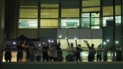 Staff light their phone flashlights and wave to supporters at the headquarters of the Apple Daily newspaper, and its publisher Next Digital, after the announcement that it will print its last edition, in Hong Kong, China June 23, 2021. (REUTERS/Lam Yik)