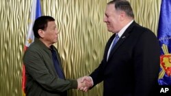 Philippine President Rodrigo Duterte, left, greets U.S. State Secretary Mike Pompeo upon arrival at Villamor Air Base in suburban Pasay city southeast of Manila, Philippines, Thursday, Feb. 28, 2019. 