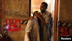 A political party worker comforts another after a suicide attack during an election campaign meeting in Peshawar, Pakistan, July 10, 2018. 