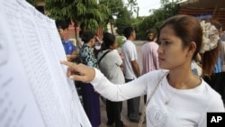 A woman finds her name on a list during a local commune election in Phnom Penh, file photo. 