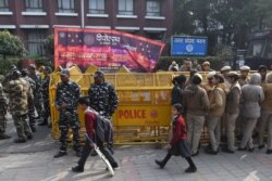 Schoolchildren walk past police outside the Uttar Pradesh Bhawan (state house) during a demonstration against the crackdown on protesters in Uttar Pradesh state, over India's new citizenship law, in New Delhi, Dec. 26, 2019.