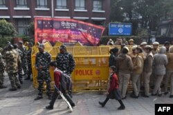 Schoolchildren walk past police outside the Uttar Pradesh Bhawan (state house) during a demonstration against the crackdown on protesters in Uttar Pradesh state, over India's new citizenship law, in New Delhi, Dec. 26, 2019.