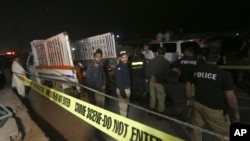 پلیس در حال بررسی یک کامیون در محل انفجار در کراچی، پاکستان، ٢٣ مرداد ۱۴۰۰