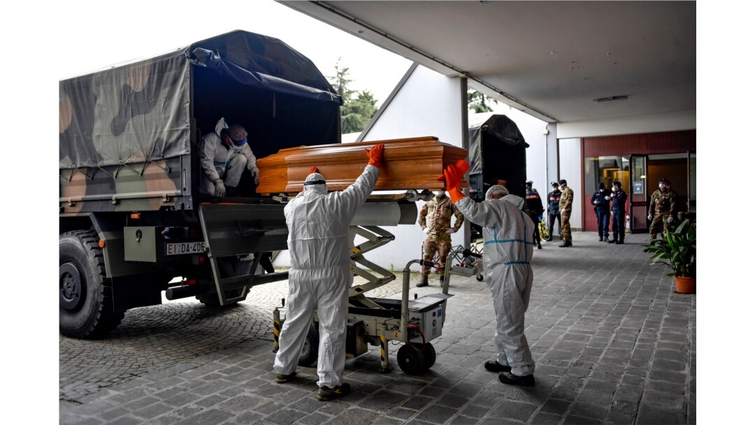 Coffins arriving from the Bergamo area are being unloaded from a military truck that transported them in the cemetery of Cinisello Balsamo, near Milan in Northern Italy, March 27, 2020.