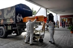 Coffins arriving from the Bergamo area are being unloaded from a military truck that transported them in the cemetery of Cinisello Balsamo, near Milan in Northern Italy, March 27, 2020.
