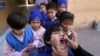 FILE - A health worker gives a polio vaccine to a child at a school in Lahore, Pakistan, on Feb. 17, 2020.