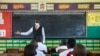 A teacher welcomes back students during a classroom lesson on day one of re-opening schools in Kampala, Uganda on Jan. 10, 2022.