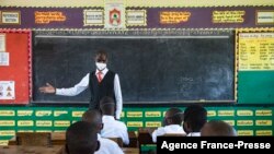 A teacher welcomes back students during a classroom lesson on day one of re-opening schools in Kampala, Uganda on Jan. 10, 2022.