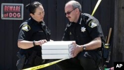 T. Abbott, left, and John Lopes from the Sacramento County Sheriff's crime scene investigation office discuss boxes of evidence gathered from the home of murder suspect Joseph DeAngelo, April 26, 2018, in Citrus Heights, Calif.