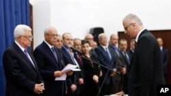 Palestinian Prime Minister elect Rami Hamdallah, right, takes oath of office in front of President Mahmoud Abbas, June 6, 2013