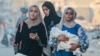 Tiga perempuan tampak berjalan meninggalkan wilayah Khan Younis di Jalur Gaza setelah tentara Israel memerintahkan warga Palestina untuk mengosongkan wilayah tersebut, pada 1 Juli 2024. (Foto: AFP/Bashar Taleb)