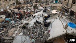 FILE — A man searches for useable items in the rubble of a house destroyed by Israeli bombardment in Rafah refugee camp, south of the Gaza Strip, on January 1, 2024.