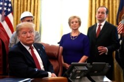 FILE - President Donald Trump listens as Labor Secretary Alex Acosta, right, speaks during a meeting with American manufacturers in the Oval Office of the White House, Jan. 31, 2019, in Washington.