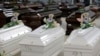 FILE - Teddy bears and flowers placed are placed on the coffins of deceased migrants inside a hangar at Lampedusa's airport, Italy, Saturday, Oct. 5, 2013.