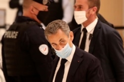 FILE - Former French President Nicolas Sarkozy arrives at the courtroom in Paris, Nov. 23, 2020.