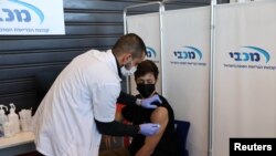 Seorang remaja menerima suntikan vaksinasi COVID-19 di Tel Aviv, Israel, 24 Januari 2021. (Foto: Ronen Zyulun/Reuters)