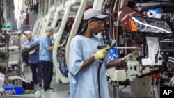FILE - Employees at the Volkswagen plant in Chattanooga, Tenn., work on the assembly of a Passat sedans, July 12, 2013. 