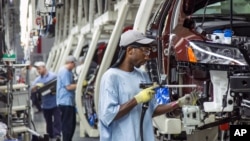 FILE - Employees at the Volkswagen plant in Chattanooga, Tenn., work on the assembly of a Passat sedans, July 12, 2013. 