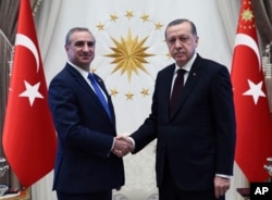 FILE - Turkey's President Recep Tayyip Erdogan, right, and Israeli Ambassador Eitan Naeh shake hands after Naeh presented his letter of credentials, in Ankara, Turkey, Dec. 5, 2016. Naeh arrived the previous week as the two countries seek to mend relations that soured after a deadly Israeli naval raid on a Turkish ship headed for Gaza.