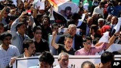 Mourners chant slogans during a symbolic funeral for the bureau chief of a local radio station in Baghdad, Iraq, March 23, 2014.