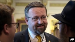 Sebastian Gorka, yang saat itu menjabat sebagai asisten deputi Presiden Donald Trump, berbicara dengan orang-orang di Ruang Perjanjian di Gedung Kantor Eksekutif Eisenhower di kompleks Gedung Putih di Washington, 2 Mei 2017. (Foto: AP)