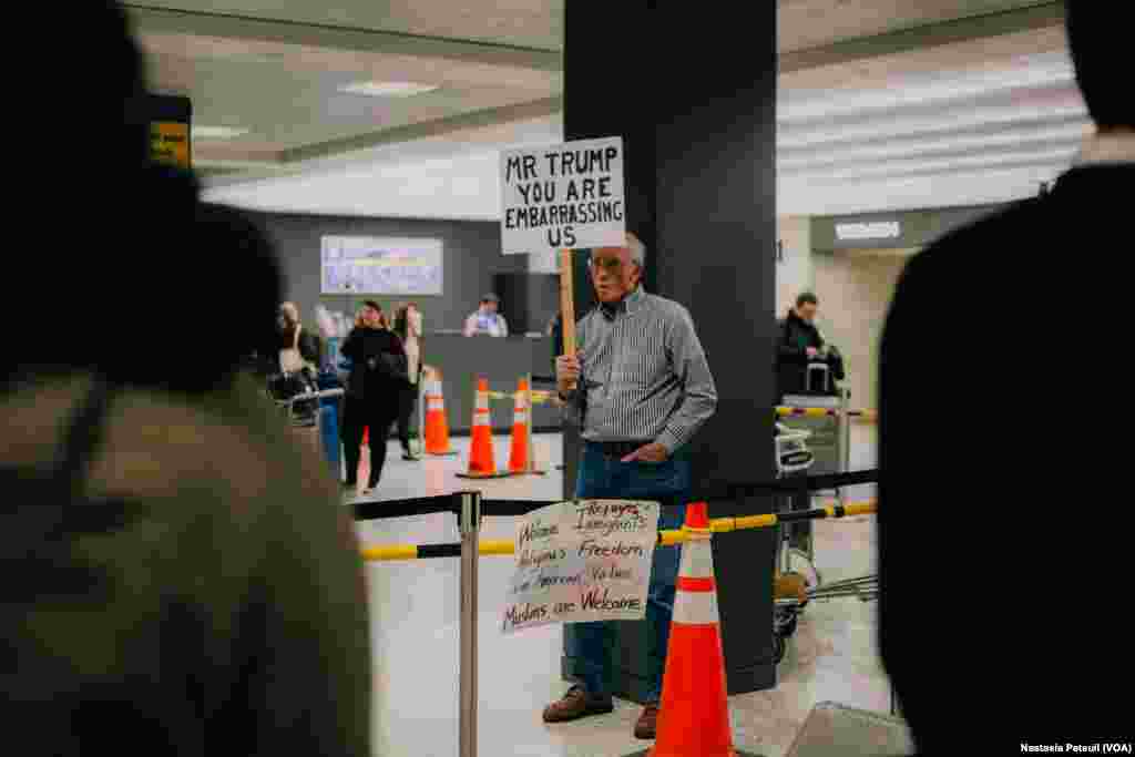 Des manifestants accueillent les touristes et les résidents à l'aéroport international de Washington DC, le 31 janvier 2017. (VOA/Nastasia Peteuil)