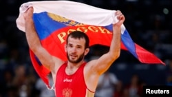 Russia's Dzhamal Otarsultanov celebrates after defeating Georgia's Vladimer Khinchegashvili on the final of the Men's 55Kg Freestyle wrestling during the London 2012 Olympic Games Aug. 10, 2012.