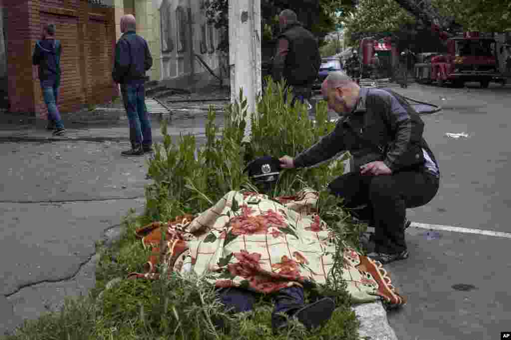 A man looks at the body of a police officer outside a police station in Mariupol, eastern Ukraine, May 9, 2014.&nbsp;