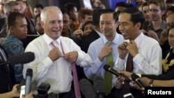 Australian Prime Minister Malcolm Turnbull, left, and Indonesian President Joko Widodo loosen their ties as they visit the Tanah Abang retail market in Jakarta, Nov. 12, 2015.