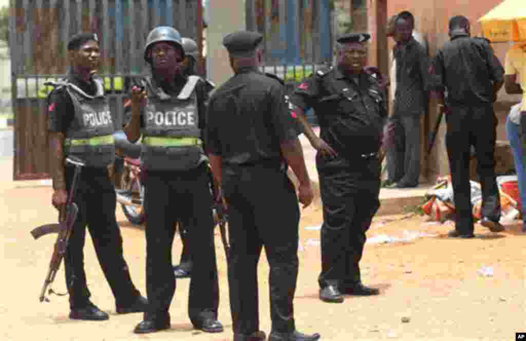 Nigerian police stand guard outside a polling Station in Ibadan, Nigeria, Saturday, April 2, 2011. Nigeria postponed its National Assembly elections Saturday as ballots and tally sheets remained missing from polling places throughout the nation, a worryi