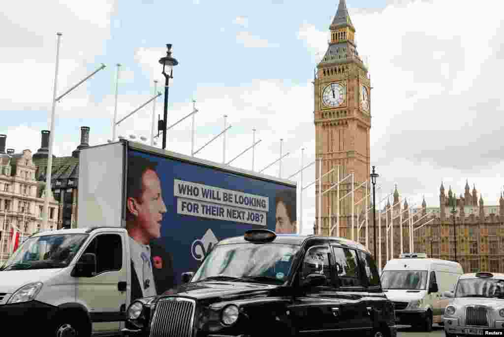 An advertising van with images of Britain's Prime Minister David Cameron and leader of the opposition Labor Party Ed Miliband drives around Parliament Square, central London, May 7, 2015.
