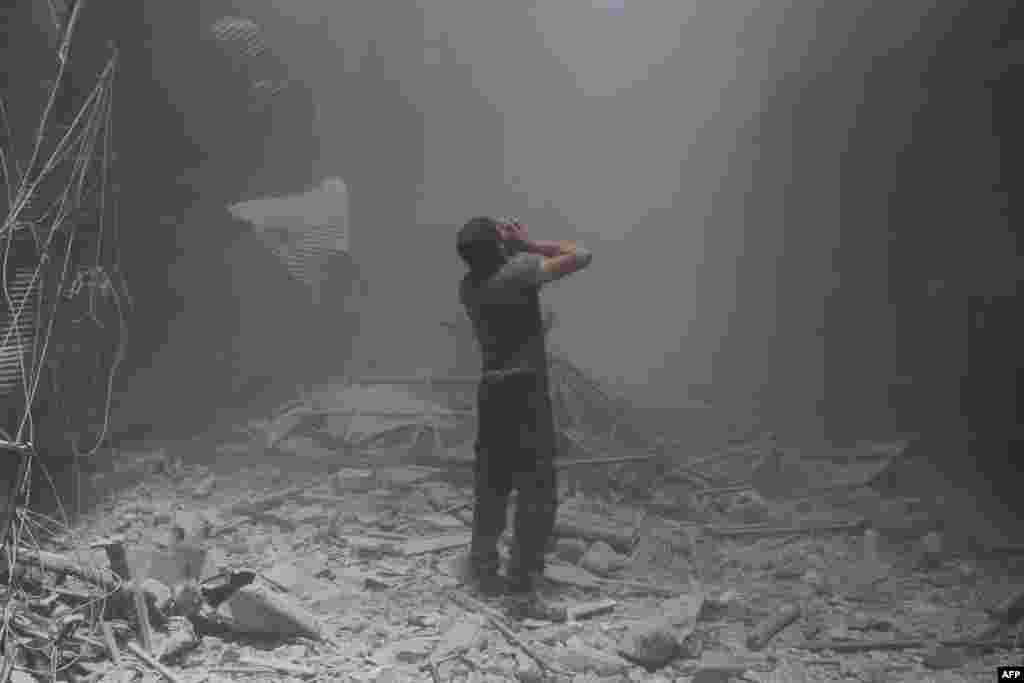 A Syrian man reacts following a reported air strike by government forces in the rebel-held neighborhood of Bustan al-Qasr.