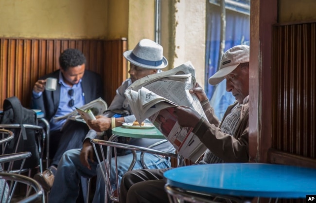 Ethiopian men read newspapers at a cafe in Addis Ababa, Ethiopia on Oct. 10, 2016. Ethiopia's government on Monday blamed Egypt for supporting outlawed rebels and forcing the declaration of the country's first state of emergency in a quarter-century as widespread anti-government protests continue.