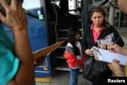 A migrant and her daughter prepare to take a bus after being released from a detention center, in McAllen, Texas, May 9, 2017.