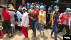 Cambodian garment workers on a lunch break outside of Propitious (Cambodia) Garment Ltd. in Kandal province, Cambodia, March 20, 2020. (Kann Vicheika/VOA Khmer) 