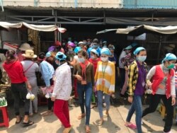 Garment factory workers wear face masks while on a lunch break near Propitious (Cambodia) Garment Ltd factory, in Kandal province, Cambodia, March 20, 2020. (Kann Vicheika/VOA Khmer)