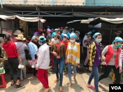 កម្មកររោងចក្រកាត់ដេរប្រភឹសឹស ខេមបូឌា ហ្គាមេន អិលធីឌី ក្នុងខេត្តកណ្តាល ចាប់ផ្តើមចេញពីរោងចក្រដើម្បីទទួលទានបាយថ្ងៃត្រង់ ដោយមានពាក់ម៉ាសគ្រប់គ្នា នៅថ្ងៃទី២០ ខែមីនា ឆ្នាំ២០២០។ (កាន់ វិច្ឆិកា/VOA Khmer)