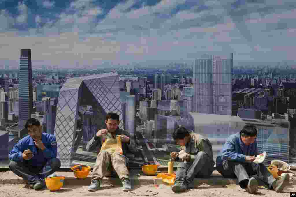کارگران ساختمانی در حال غذا خوردن در مقابل یک تابلوی هنری در پکن