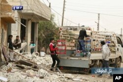 In this photo provided an. 4, 2018 by the Syrian anti-government activist group, Edlib Media Center, EMC, which has been authenticated based on its contents and other AP reporting, shows Syrian citizens load their belongings onto a pickup truck to flee from Russian airstrikes, in Tel al-Toukan village, eastern Idlib province.