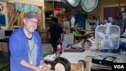 Michael Rohde demonstrates a pendulum-powered light that he's perfecting at OlyMEGA, the Olympia, Washington maker space. (Tom Banse for VOA)