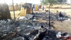 Smoldering ashes are seen on the ground in Budu near Maiduguri on July 28, 2019, after an attack by Boko Haram fighters on a funeral left 65 people dead. (Audu Marte/AFP)